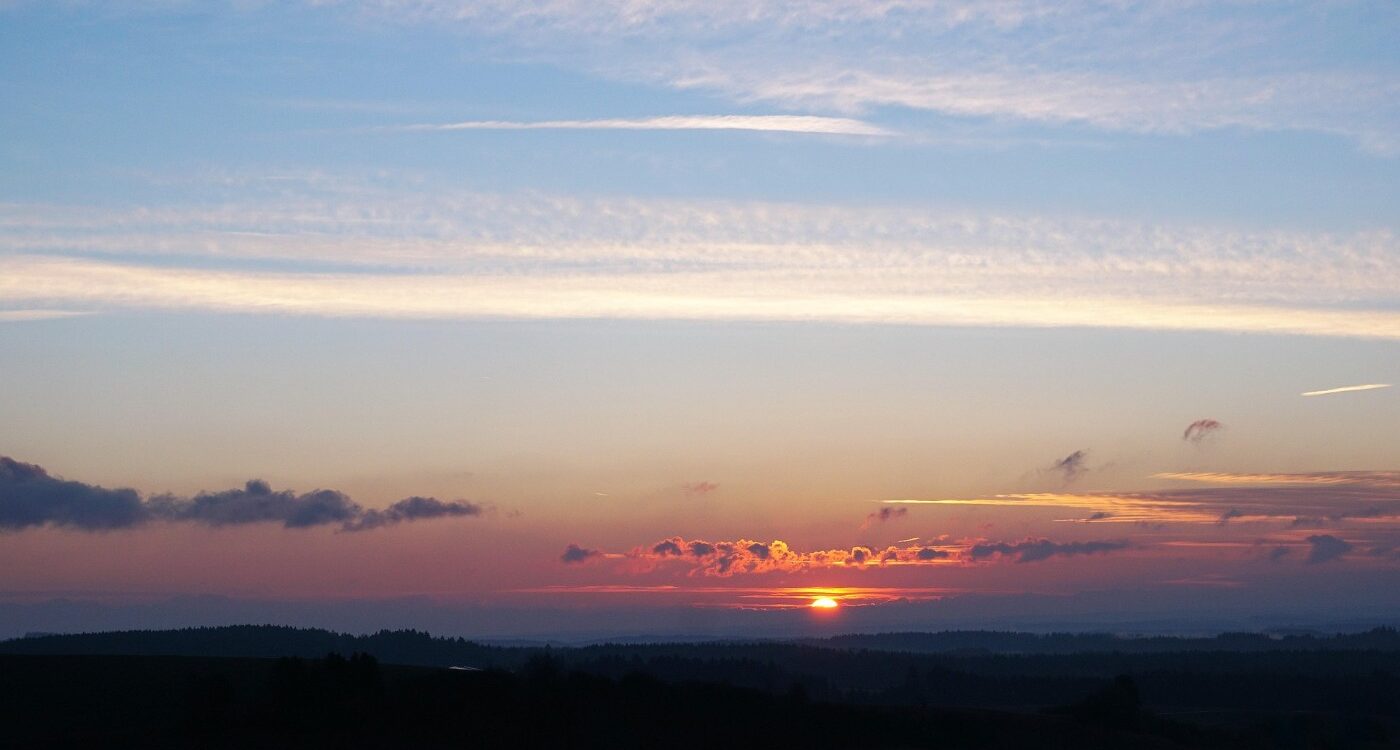 Clouds with silver lining and sun in distance - Finding the Silver Lining When Life Breaks You Open