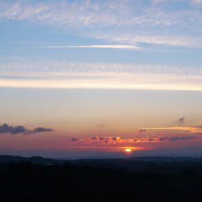 Clouds with silver lining and sun in distance - Finding the Silver Lining When Life Breaks You Open
