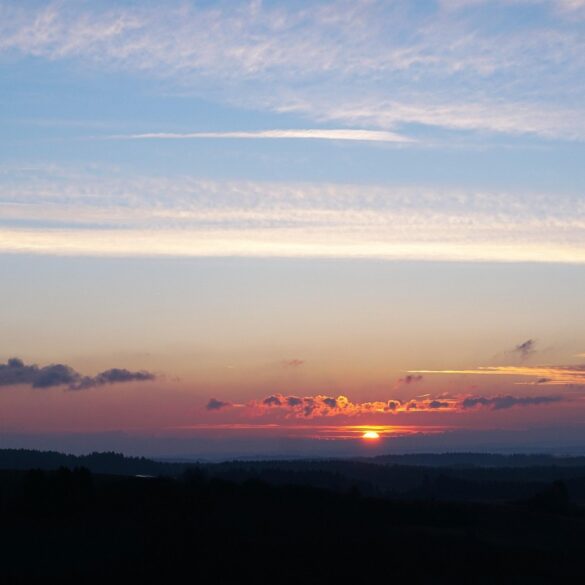 Clouds with silver lining and sun in distance - Finding the Silver Lining When Life Breaks You Open