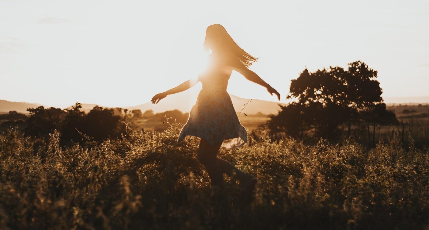 Young woman running freely through field - 3 Anchors to Help You Avoid Your Ego’s Voice