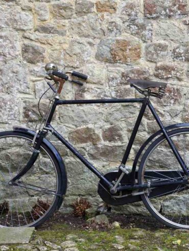 Traditional bicycle parked outdoors against stone wall - "Creepy Creatures" and 4 More New Poems About Life’s Seasons